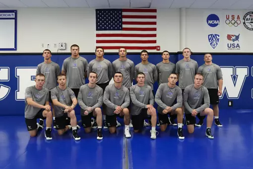 Air Force wrestling freshmen, with stern faces, pose for a group photo in the wrestling room