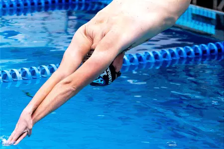 Tyler Stargardt dives into the pool at Cadet Natatorium