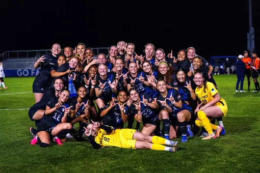The women's soccer team poses together after defeating UC Davis 3-1