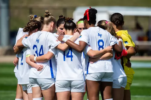 The women's soccer team huddles