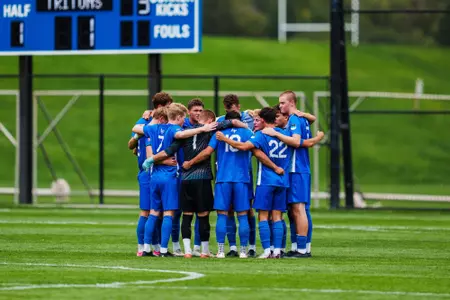 The Men's Soccer Team Huddles at midfield