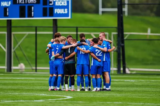 The Men's Soccer Team Huddles at midfield