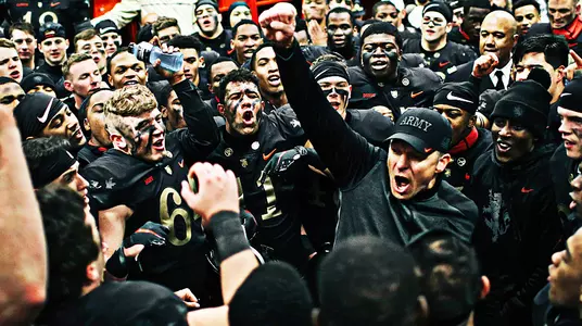 Head football coach Jeff Monken celebrates with the team after their 17-10 victory over rival Navy