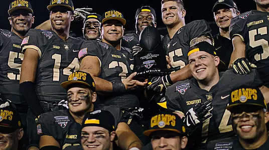 Several players hold the 2019 Lockheed Martin Armed Forces Bowl trophy after their 70-14 rout of Houston