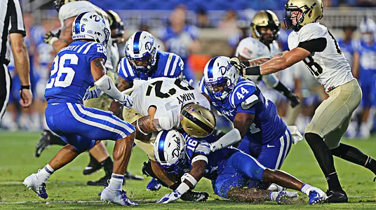 Calen Holt muscles his way forward for Army West Point football team despite being tackled by four Duke defenders