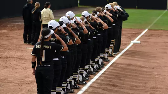 Softball team saluting during anthem