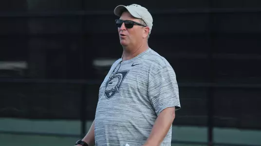 Head women's tennis coach Paul Peck coaching at practice