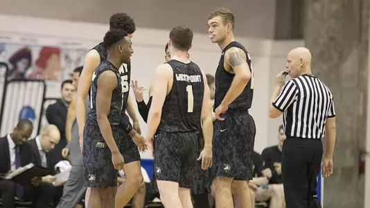 Men's basketball huddles at FDU