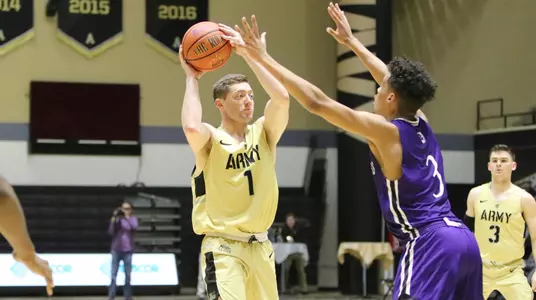 Jordan Fox looks to pass with a Holy Cross defender on him