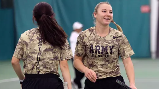 Genevieve McCormick greets Paola Bou in doubles play against Rutgers