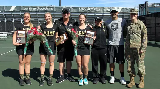 Seniors Melanie Allen, Kirby Einck and Genevieve McCormick posing with the coaching staff for senior day