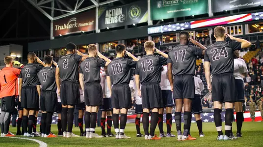 Men's soccer lines up for the national anthem