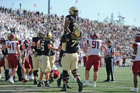 Oct 15, 2022; West Point, New York, USA; Army Black Knights quarterback Jemel Jones (7) is lifted up by offensive lineman Jordyn Law (77) after scoring a touchdown against the Colgate Raiders during the second half at Michie Stadium. Mandatory Credit: Danny Wild-USA TODAY Sports