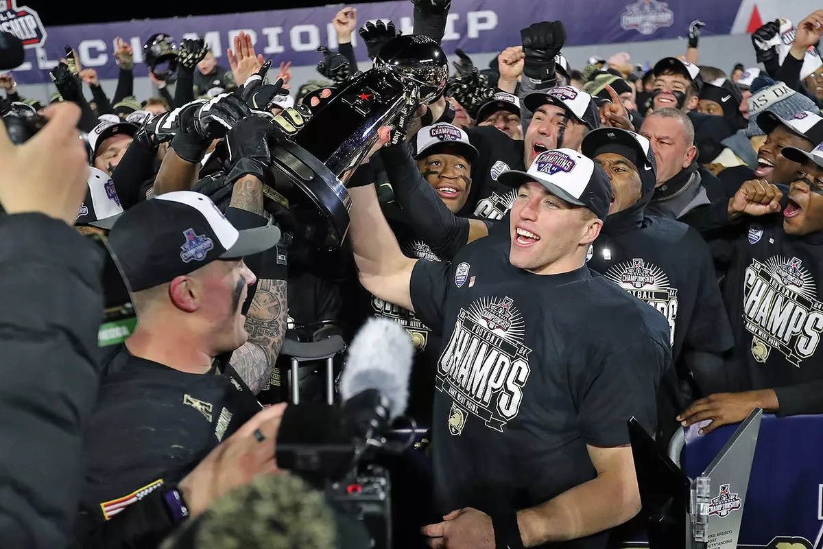 Bryson Daily Hosts the AAC Championshp Trophy after beating Tulane