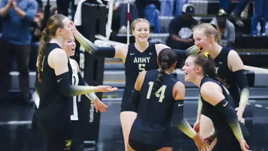 Volleyball Team Celebrating A Point Against Loyola Maryland