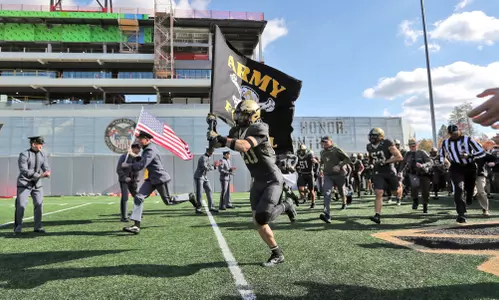 Nov 8, 2025; West Point, New York, USA; Army Black Knights safety Casey Larkin (20) leads his teammates out to the field with a flag before a game against the Temple Owls during the first half at Michie Stadium. Mandatory Credit: Danny Wild-Imagn Images