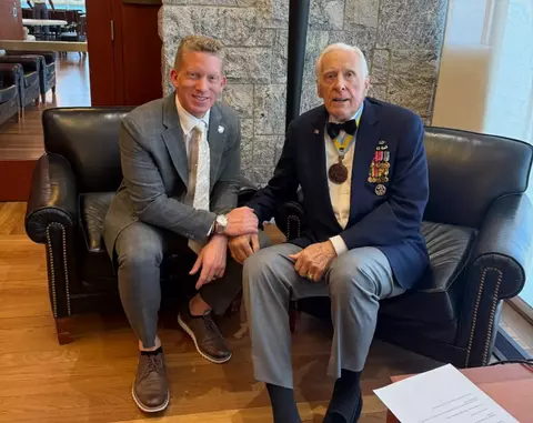 Tom Theodorakis sitting with Pete Dawkins at the USMA Jefferson Library.