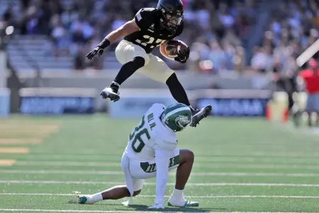 Oct 12, 2024; West Point, New York, USA; Army Black Knights running back Samari Howard (27) hurdles over UAB Blazers cornerback Kelvin Hill (36) during the first half at Michie Stadium. Mandatory Credit: Danny Wild-Imagn Images