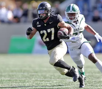 Oct 12, 2024; West Point, New York, USA; Army Black Knights running back Samari Howard (27) runs by UAB Blazers linebacker Jason Riles Jr. (27) during the second half at Michie Stadium. Mandatory Credit: Danny Wild-Imagn Images