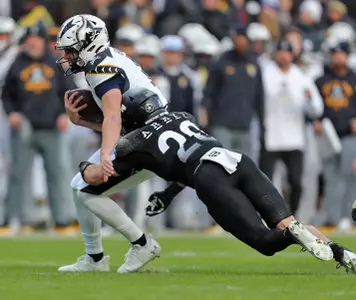 Dec 14, 2024; Landover, Maryland, USA; Navy Midshipmen quarterback Blake Horvath (11) is brought down by Army Black Knights defensive back Casey Larkin (20) during the first half of the the 125th Army-Navy game at Northwest Stadium. Mandatory Credit: Danny Wild-Imagn Images