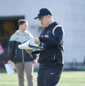 Coach Yanagi reading his clipboard at 2025 Spring Practice 2025