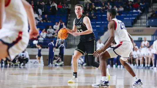 Dylan Benner Dribbles the Ball Past the Navy Defender