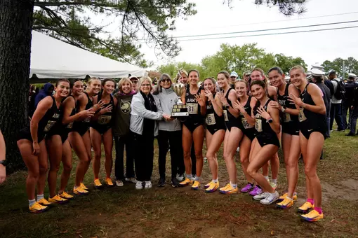women's cross country wins the Army-Navy Meet, poses with trophy
