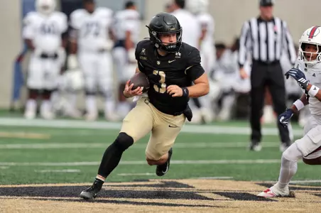 Army quarterback Cale Hellums evades in FAU defender while carrying the ball in Army's 56-24 win on Oct. 17.