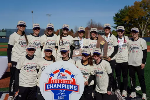 Women's cross country poses with trophy after four-peating Patriot League Championships