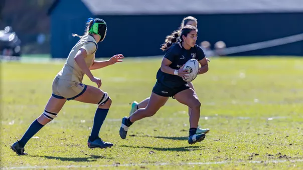 Yesenia Morales runs with the ball during a women's rugby match