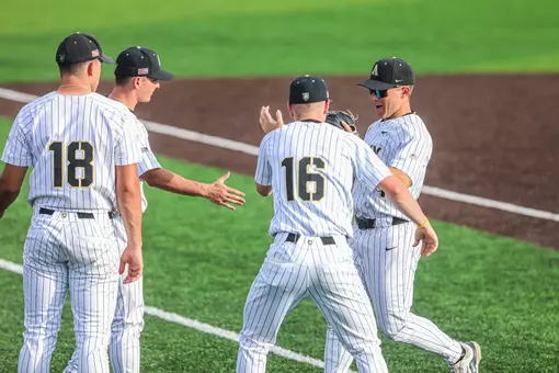 Zac Farrell runs off the field and is greeted by high-fiving teammates.