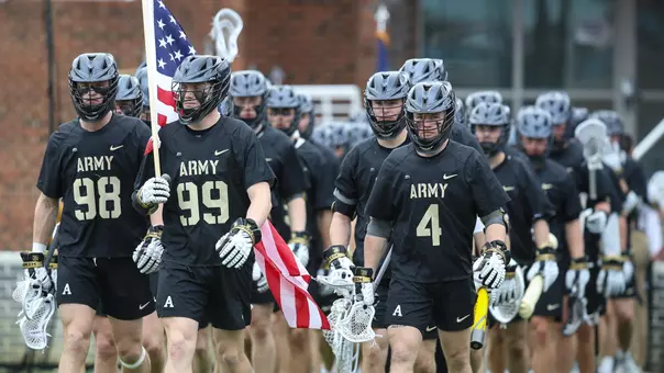 Men's Lacrosse team walks out to field for pregame warmups in black uniforms at UNC led by John Sullivan and Evan Plunkett.