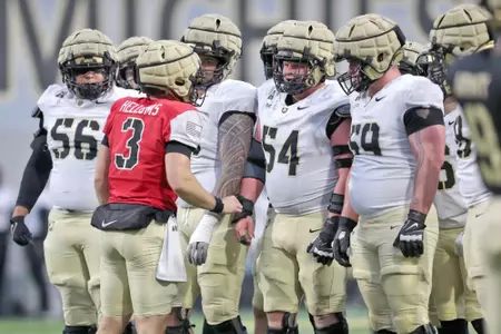 Army Football huddle with the quarterback talking to the offensive line at the 2025 Spring Game.