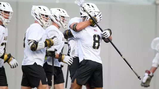 Men's Lacrosse's Drew Miller and Isaiah Rose hug in celebration after Miller scored a goal against Colgate.