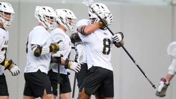 Men's Lacrosse's Drew Miller and Isaiah Rose hug in celebration after Miller scored a goal against Colgate.
