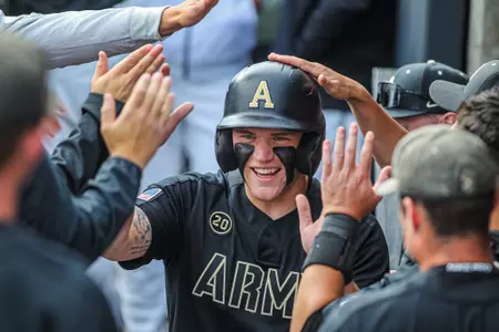 Josiah Overbeek is greeted by teammates in the dugout.