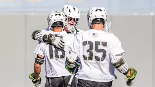 Gunnar Fellows hugs Robert Simone after scoring a goal and Brayden Fountain walks towards them.
