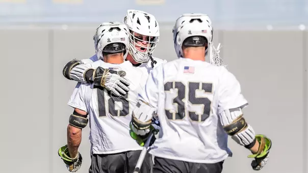 Gunnar Fellows hugs Robert Simone after scoring a goal and Brayden Fountain walks towards them.