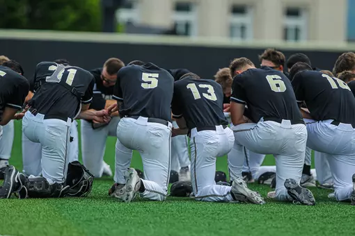 The Army baseball team huddles before playing Holy Cross at Doubleday Field.
