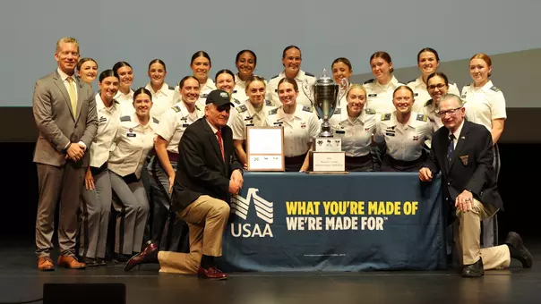 Army Women's Soccer team photo on stage at Eisenhower Hall with a couple of members of the Class of 1970 after winning the MacArthur Cup for Army Athletics Team of the Year at the annual Black Knight Awards.