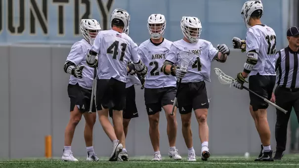 Evan Plunkett high fives teammates after a goal against Loyola Maryland.