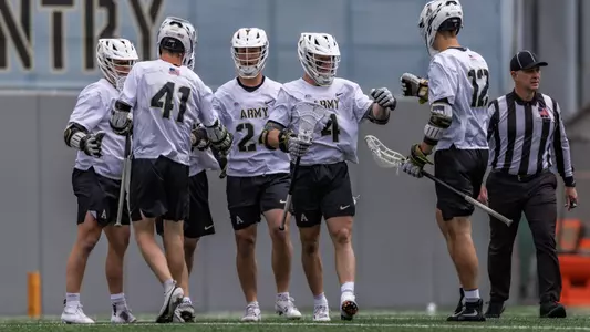 Evan Plunkett gives Aiden Weisenborn a fist bump during group celebration after scoring against Loyola Maryland.