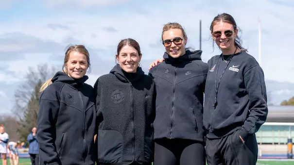 Noto Family Head Coach Michelle Tumolo, Associate Head Coach Sammy Cermack and Assistant Coaches Charlotte Sofield and Jordan Dean pose for a photo before a game at Bucknell on March 21, 2026