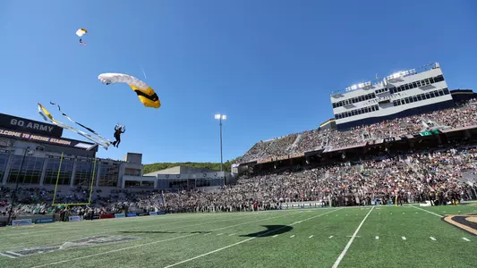 Parachuter ready to land on the field at Michie Stadium during pregame of a football game.