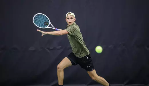 Army West Point Men's Tennis player swinging a tennis racket in a tennis match