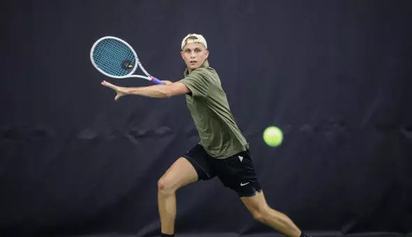 Army West Point Men's Tennis player swinging a tennis racket in a tennis match