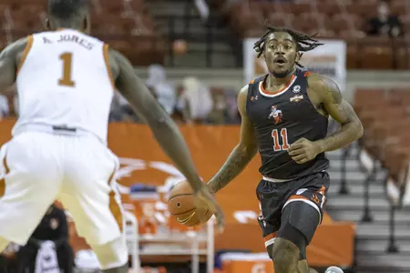 Javion May dribbles against Texas