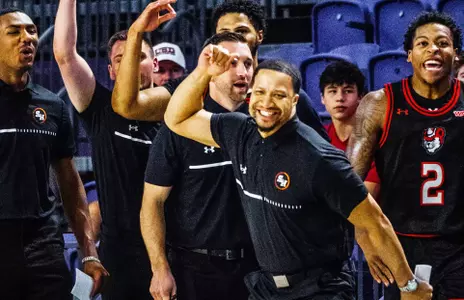 Assistant coach Justin Bailey celebrates a made shot against Northern Illinois