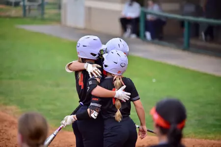 Members of the softball team meet at home plate
