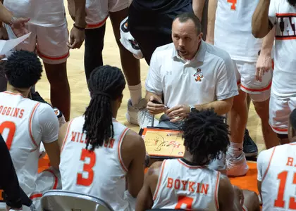 Head coach Chris Mudge talks to the team during a timeout